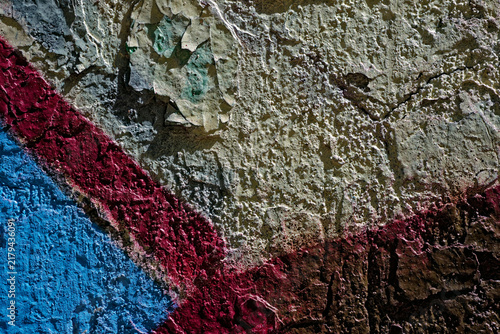 Diagonal blue and burgundy color blocks on cracked stucco texture of historic Soviet constructivism building wall with crevice pattern