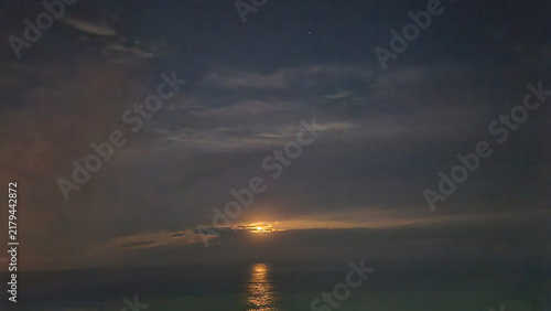 фотографія Moonlight filtering through stratocumulus beneath an altostratus veil, creating