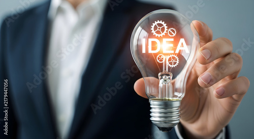 Professional Business Person Holding a Glowing Light Bulb Concept Representing Innovation Strategy and Creative Problem Solving