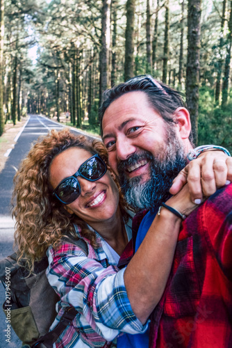 Bild auf Leinwand Happy adult couple taking a smiling selfie together while traveling and embracin