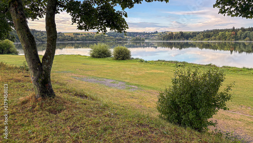 Scenic lakeside view with calm waters and greenery