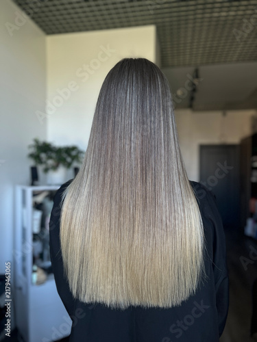 Long straight balayage blonde hair rear view in salon