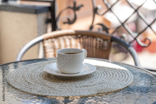 Konstfotografi Freshly cup of Coffee on a Sunny Outdoor Cafe Table
