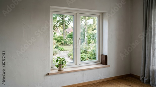 Bright Window View of a Lush Green Garden with a Potted Plant.