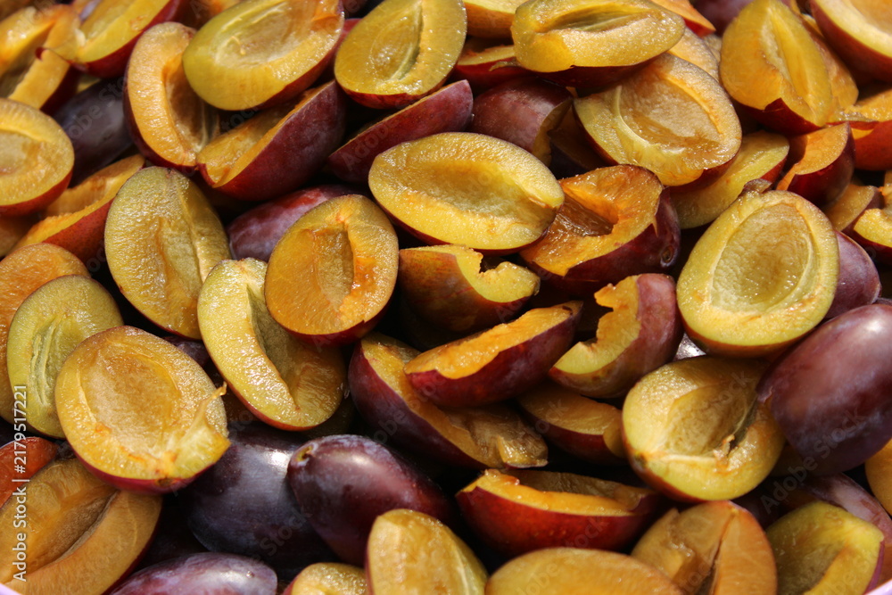 Obraz premium Plum halves ready for preservation in a bustling kitchen during summer preparations