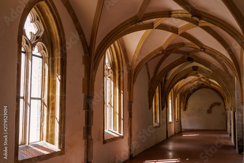 Foto Gothic cloister hallway with vaulted ceiling and traceried stone windows in Blau