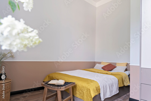 Obraz na plátně Interior of a bedroom with double bed with yellow blanket and pillow and white wall