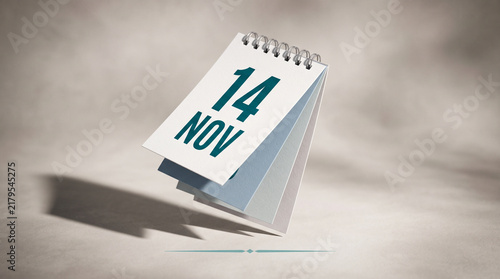 Spiral desk calendar page flipping to november 14th date reminder with spiral notebook autumn date daily planner page turning