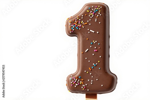 Chocolate number one shape on stick with colorful sugar sprinkles toy.