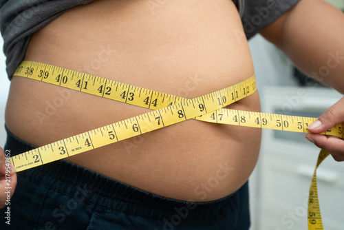 Photography Asian woman with fat belly big size overweight and obesity with measure tape