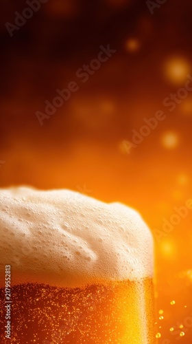 A close-up of a frothy beer with a warm, golden background and sparkling bubbles