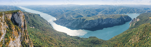 Foto Panoramic aerial view of dramatic limestone cliffs framing a wide Danube river winding through Iron Gate gorge and valleys at sunset
