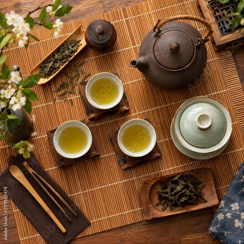 Traditional Asian Green Tea Set Flat Lay with Teapot and Teacups on Bamboo Mat
