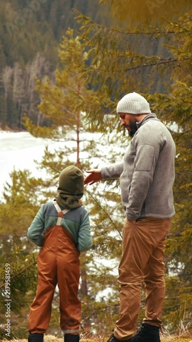 Father and son hiking in the winter forest