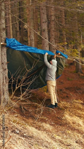 People building survival shelter in forest
