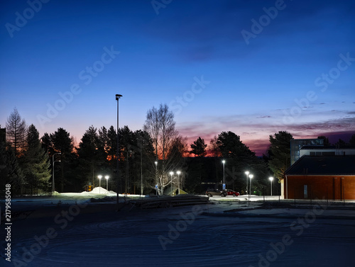 winter town at blue hour twilight in Kemijärvi, Finland with street lights illuminating the snow and trees