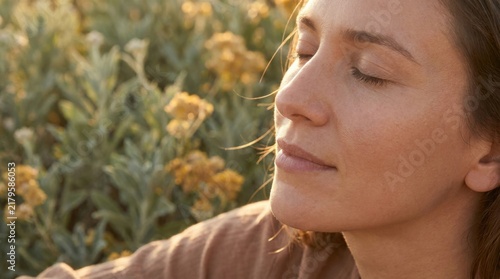 Close Up Serene Young Woman with Closed Eyes Breathing in Golden Hour