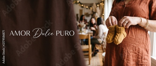 Pregnant woman holding baby booties at cozy baby shower party with friends in warm indoor setting, expecting mother celebrating new life and motherhood concept with copy space and rustic decor.