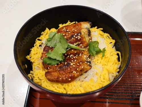 Foto Glazed grilled conger eel on rice with shredded egg and sesame