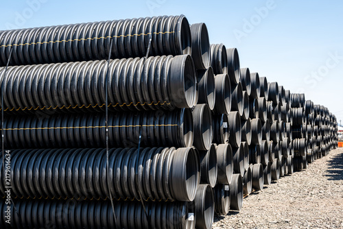 View of stacked black corrugated plastic pipes in an industrial storage yard in Eugene, Oregon, United States.