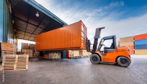 orange forklift truck loading wooden pallets into shipping container at industrial warehouse loading dock