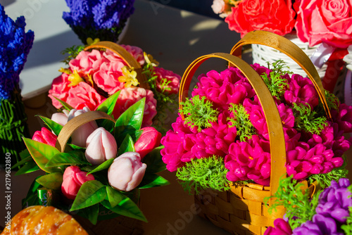 Bright, natural, eco-friendly soap shaped like flowers in a basket. Decorative, souvenir-style shaped soap. Floral-scented soap, a gift. Soap shaped like a bouquet of flowers