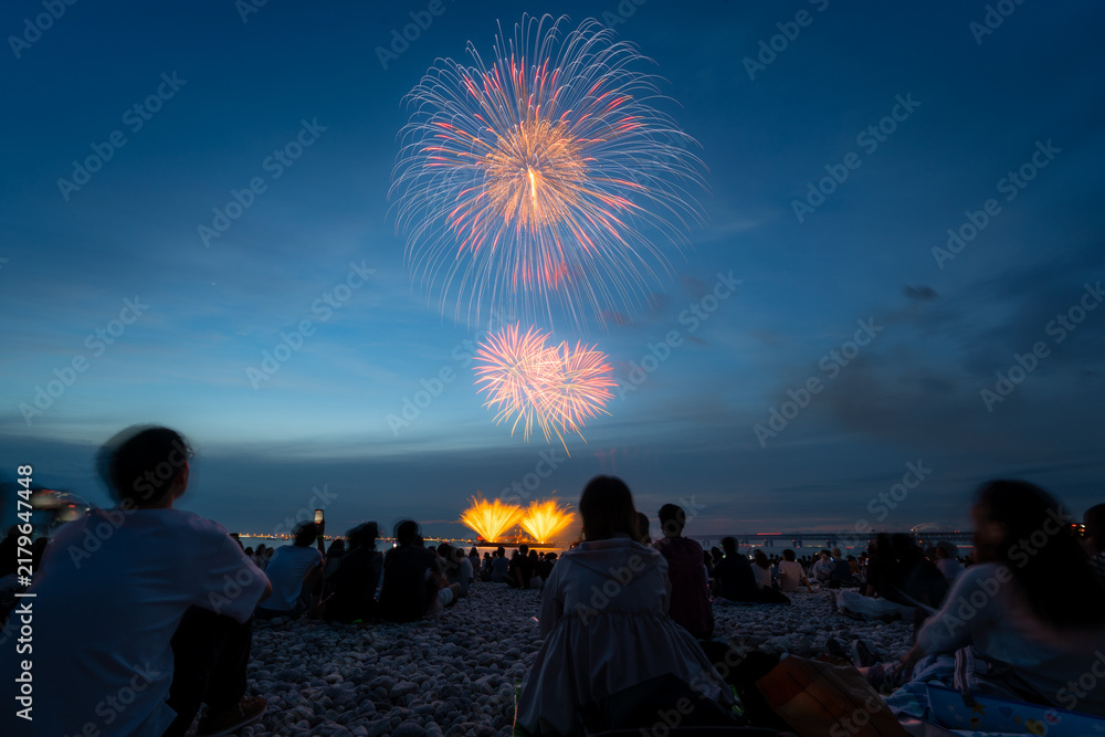 Obraz premium Two fireworks and golden fountains above a crowd in Osaka Japan