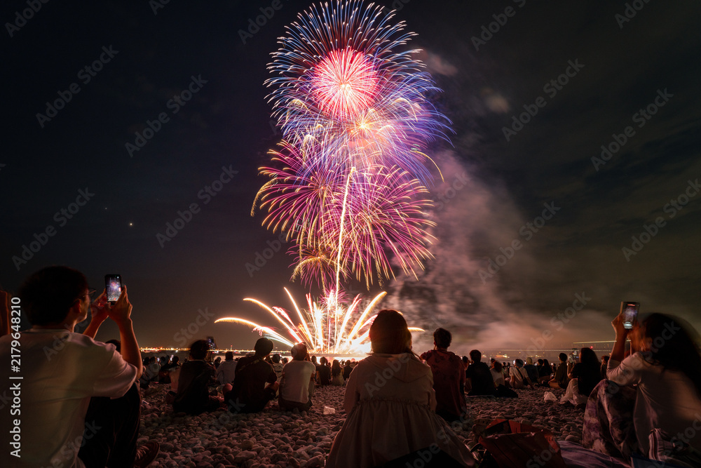 Fototapeta premium Grand fireworks finale above a beach crowd in Osaka Japan