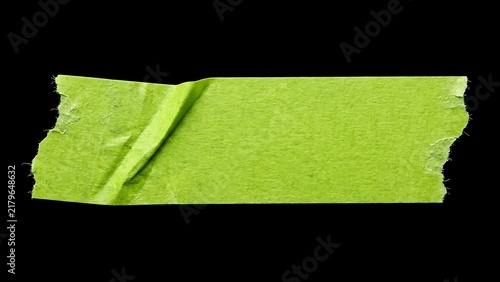 Bright green masking tape strip with a folded corner and torn edges