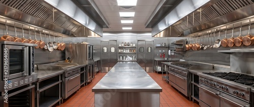 Professional commercial kitchen interior with stainless steel equipment and hanging cookware