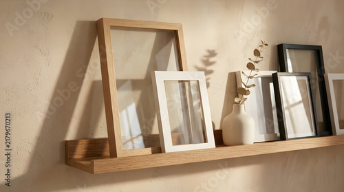 Stylish empty photo frames on wooden shelf, cozy home decor background, minimal aesthetic.