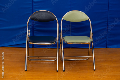 Chairs positioned side by side in an indoor space with blue background