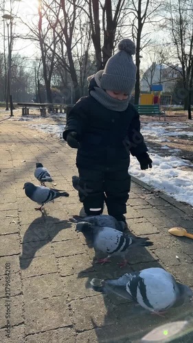 Toddler feeding birds on walkway