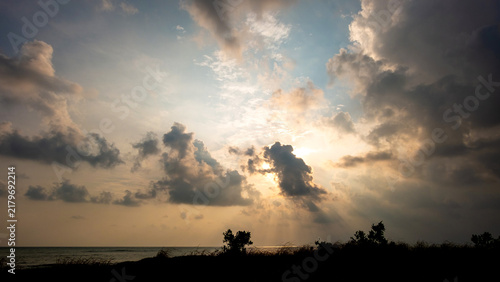 Foto Dramatic Sunset Sky with Crepuscular Rays Over Ocean Horizon