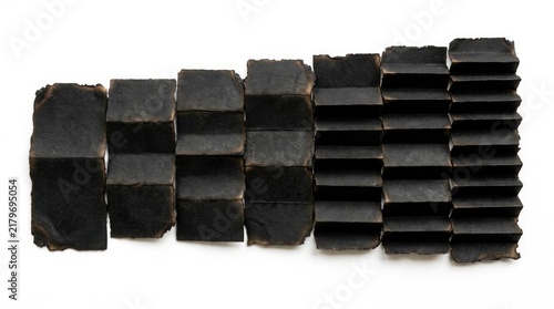 Accordion folded black burnt paper strips arranged linearly for minimalist graphic design composition