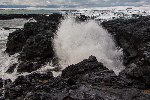 Big ocean waves crashing into rocky shore in Iceland