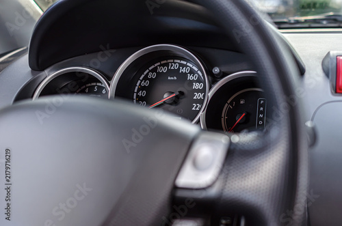 Modern car dashboard showing the speedometer, gauge cluster, and steering wheel.