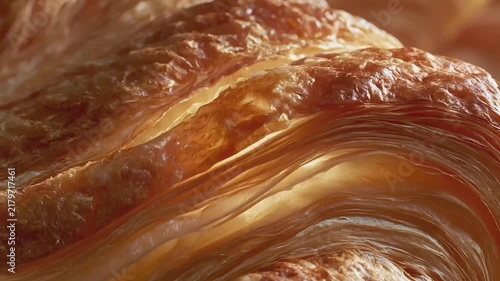 Paris, France, Europe. A closeup of a freshly baked croissant, showcasing its goldenbrown, flaky texture and intricate swirl patterns. The background is out of focus, emphasizing the pastrys details.