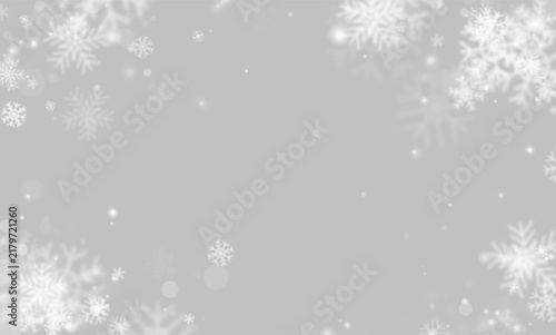 Фотография White snowflakes float delicately over a dark background
