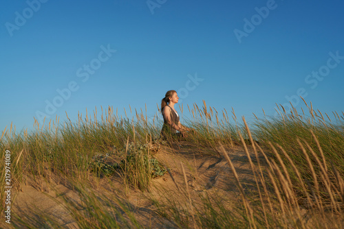 Woman Practicing Yoga on Beach Dunes at Sunset for Fitness