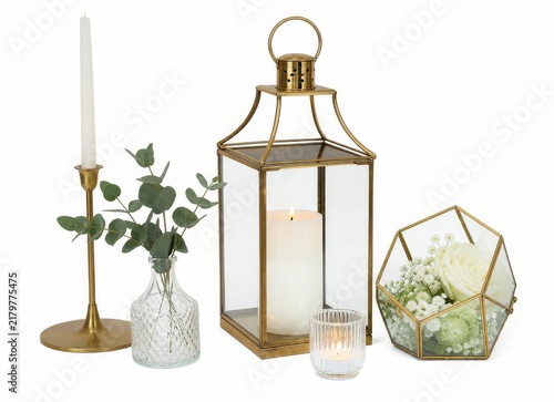 Goldene Tischdekoration mit Laterne, Kerzen, Vase und Terrarium auf weissem Hintergrund