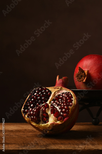 Pomegranate Still Life. Two ripe pomegranates one split open showing the seeds.