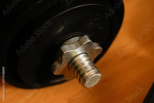 Dumbbell spinlock collar securing a weight plate on a barbell