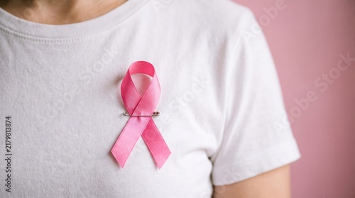 A person wearing a pink ribbon symbolizing support for breast cancer awareness and research