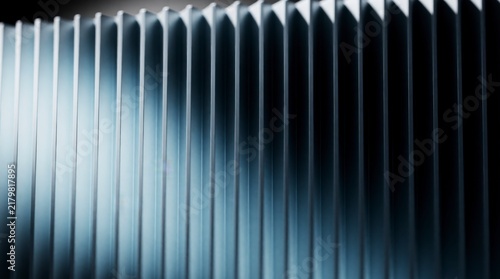 Abstract close-up of metallic cooling fins or heat sink with strong light and shadow