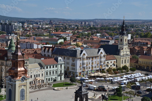 Fotografie Aerial view of Oradea, Romania, featuring the historic city center, colorful rooftops, elegant architecture, Crișul Repede River, and distant Apuseni Mountains under a clear sky