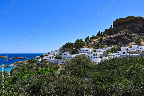 Whitewashed hillside village with hilltop fort and blue sea - Lindos, Rhodes Island, Greece