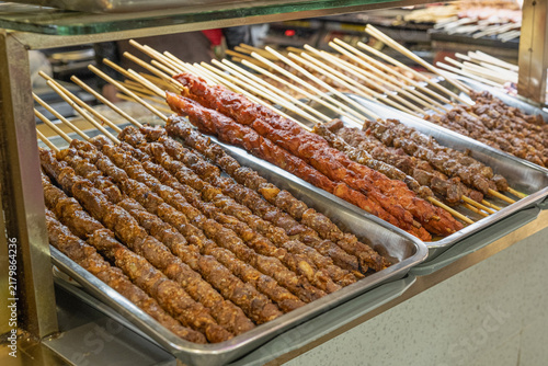 Quadro su tela Chinese meat skewers called Chuan or Chuanr with spices on display at an Asian street food market stall