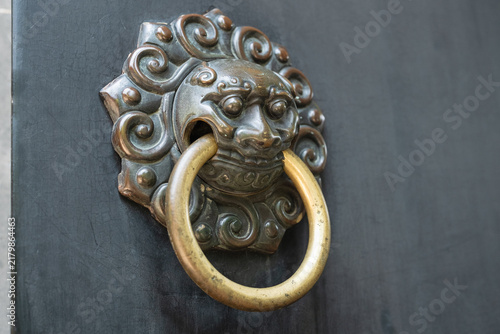 Obraz na płótnie ancient door knocker shaped like mythical lion head on dark wooden gate