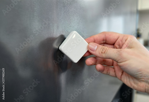 Obraz na płótnie Blank rhombus souvenir magnet held by hand on refrigerator, ai generated. Magnets attached to steel fridge surface by arm. Home decor, clean design for memory photo or vacation pin concept.